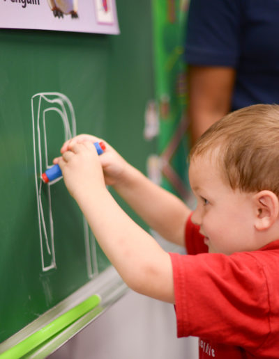Boy drawing on a chalkboard at Spring Hill Academy Preschool